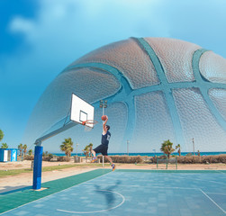 basketball player dunking by the sea