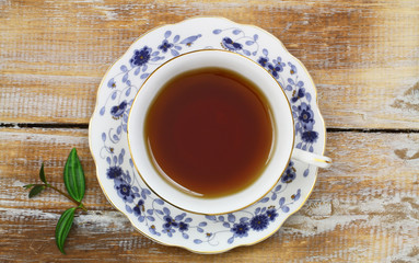 Tea in vintage cup on wooden surface