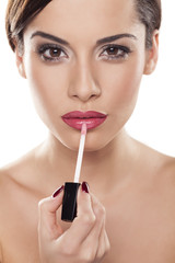 young beautiful woman applied lip gloss