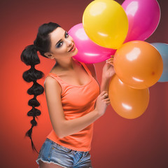 Girl with balloons in studio. Brunette.