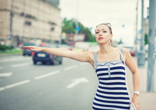 Young Beautiful Woman Trying To Hail A Cab In The City