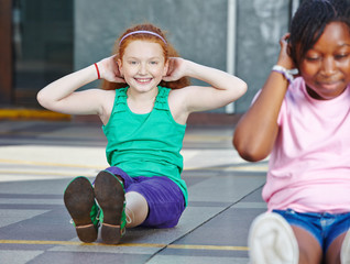 Mädchen macht Sit-Ups in Schule