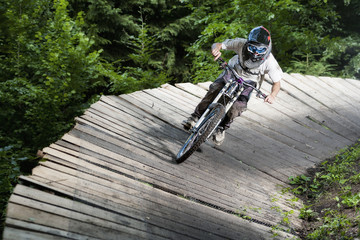 Mountainbiker rides on wooden platform