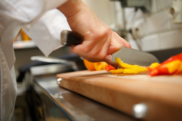 closeup on hands cutting yellow pepper