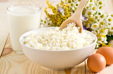 Cottage cheese with milk and eggs on the meadow flowers backgrou