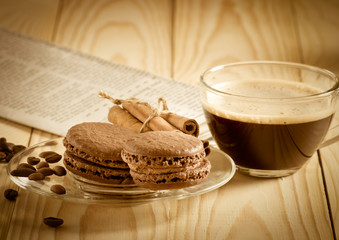 Coffee cup with macaroon and newspaper