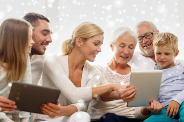 smiling family with tablet pc computers at home