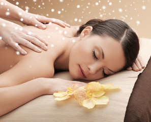 Obraz na płótnie Canvas beautiful young woman in spa salon getting massage