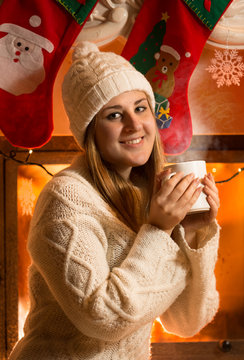 portrait of beautiful woman in woolen sweater drinking tea at fi