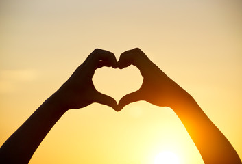 Fototapeta premium love shape hand silhouette at sunset