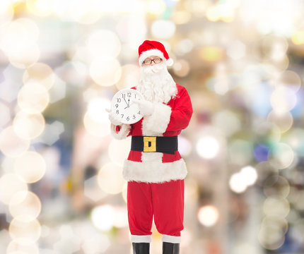 man in costume of santa claus with clock
