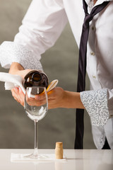 Man waiter pouring wine into glass.
