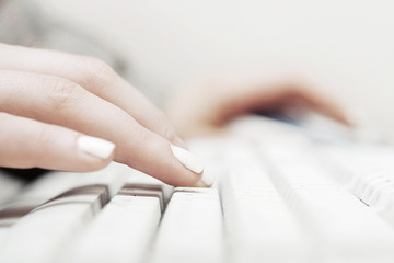 Female hands typing on computer keyboard
