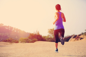 woman runner athlete running at mountain trail