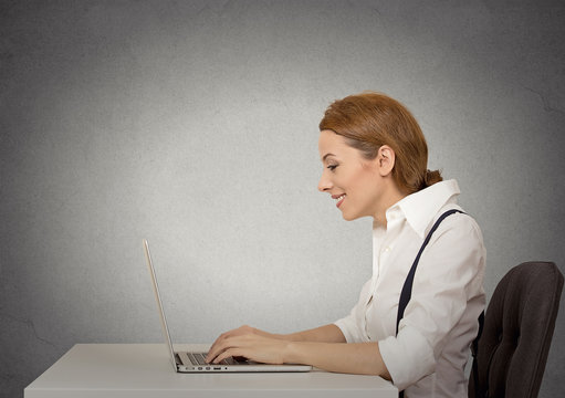 Side profile happy woman using working her laptop computer