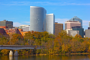 Modern building near Potomac River and trees with fall foliage.