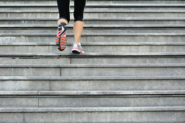 	spory woman legs running up on stone stairs  - obrazy, fototapety, plakaty