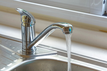 Kitchen faucet with a flowing water