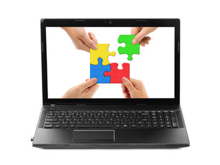 Hands and puzzle in computer notebook
