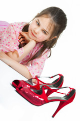 Portrait of little girl with high-heeled shoes