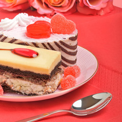 Valentine cakes, tarts and red roses on the red tablecloth