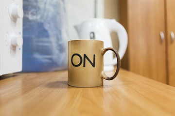 Tea mug with on letters on body standing in middle of table