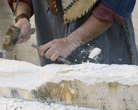 sculptor at work on a sandstone block, motion blur