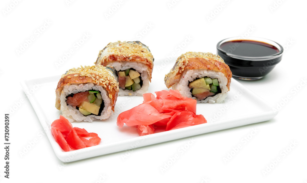 Wall mural Roll with eel, avocado and salmon on a plate on a white backgrou