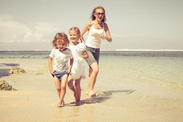 Happy family running on the beach at the day time