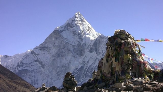 Thamserku Peak and prayer flags Lungta (flying horses). Nepal.