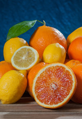 Oranges and lemons on a wooden table on a blue blackground