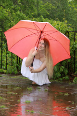 Eine Frau sucht unter einem Regenschirm Schutz vor Regenwetter