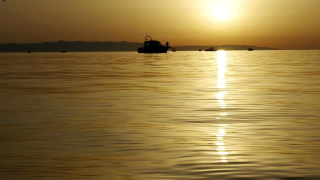 Small boats at sea in golden sunset