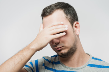 Fototapeta premium Depressed young man holding head in hands