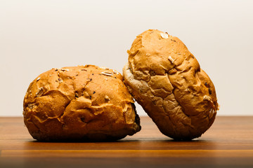 Two spelt buns on wood