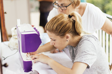 Close up young woman sewing