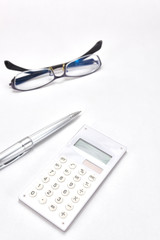 電卓とボールペンとメガネ