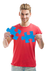 Young man holding a puzzle piece