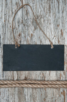 Chalkboard with rope on the old wood