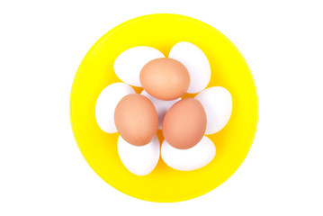 several white eggs on top of brown eggs in a yellow beautifully