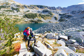 Woman backpacker standing mountain lake.