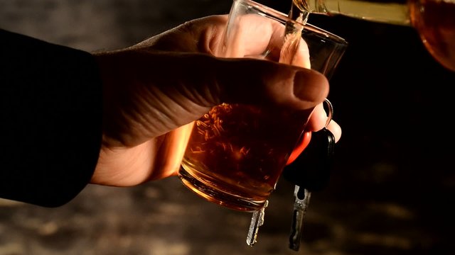 pouring alcohol into the glass,driver hold ignition key