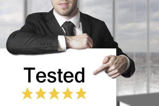 businessman pointing on sign tested