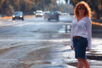 Portrait of red-haired happy woman in the rain