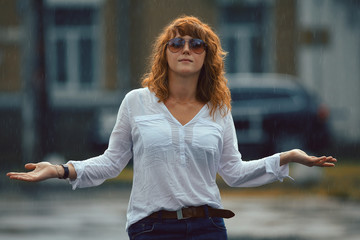 Portrait of red-haired happy woman in the rain
