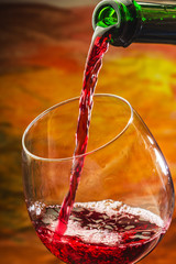 Wine pours into the glass of the bottle