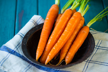 Fresh organic carrots in retro bowl