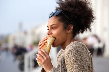 Papier Peint photo Lavable Snack Beautiful young woman eating sandwich outdoors