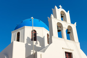 White church with a blue roof seen in Oia