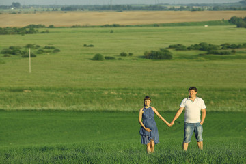 Fototapeta premium man and a pregnant woman in a summer field